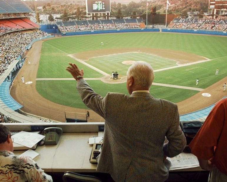 Two days after retiring, Lasorda waves to fans and players from the press box as a game against the Florida Marlins gets underway in July 1996.