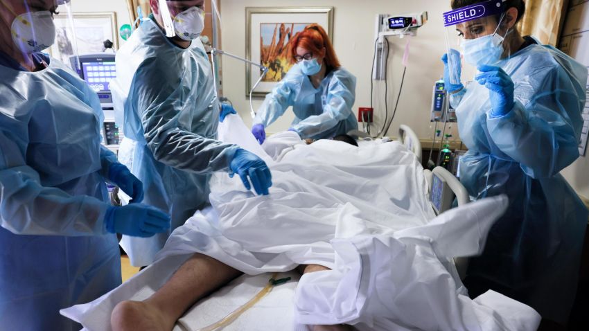 APPLE VALLEY, CALIFORNIA - JANUARY 06: Clinicians prepare to re-position a COVID-19 patient into the supine position at Providence St. Mary Medical Center amid a surge in COVID-19 patients at the hospital and across Southern California on January 6, 2021 in Apple Valley, California. The hospital is operating at over 200 percent of its normal ICU (Intensive Care Unit) capacity and is currently converting some patient rooms into ICU rooms to treat the increase in COVID-19 patients requiring ICU-level care. California has issued a new directive ordering hospitals with space to accept patients from other hospitals which have run out of ICU beds due to the coronavirus pandemic. (Photo by Mario Tama/Getty Images)