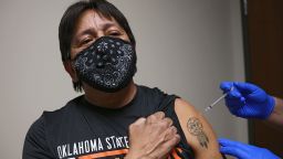 Tim King, a citizen of the Cherokee Nation and a fluent Cherokee language speaker, receives a COVID-19 vaccination at the Cherokee Nation Outpatient Health Center in Tahlequah on Thursday. On his left arm is a tattoo of a dream catcher with the word for his tribe in Cherokee.