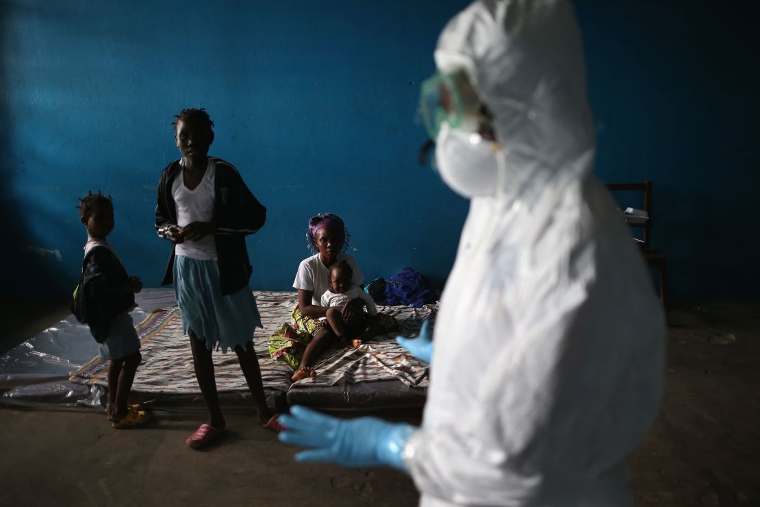 A Liberian health worker speaks with families in a classroom being used as an Ebola isolation ward on August 15, 2014 in Monrovia, Liberia.