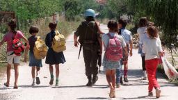 A United Nations Protection Force (UNPROFOR) French soldier escorts on August 14, 1993 a group of children after they left their Kobilja Gava school in Sarajevo neighbourhood a few hundred meters from the front line. A Serb sniper killed already a young girl and wounded another one from this school. AFP PHOTO GABRIEL BOUYS (Photo by Gabriel BOUYS / AFP) (Photo by GABRIEL BOUYS/AFP via Getty Images)