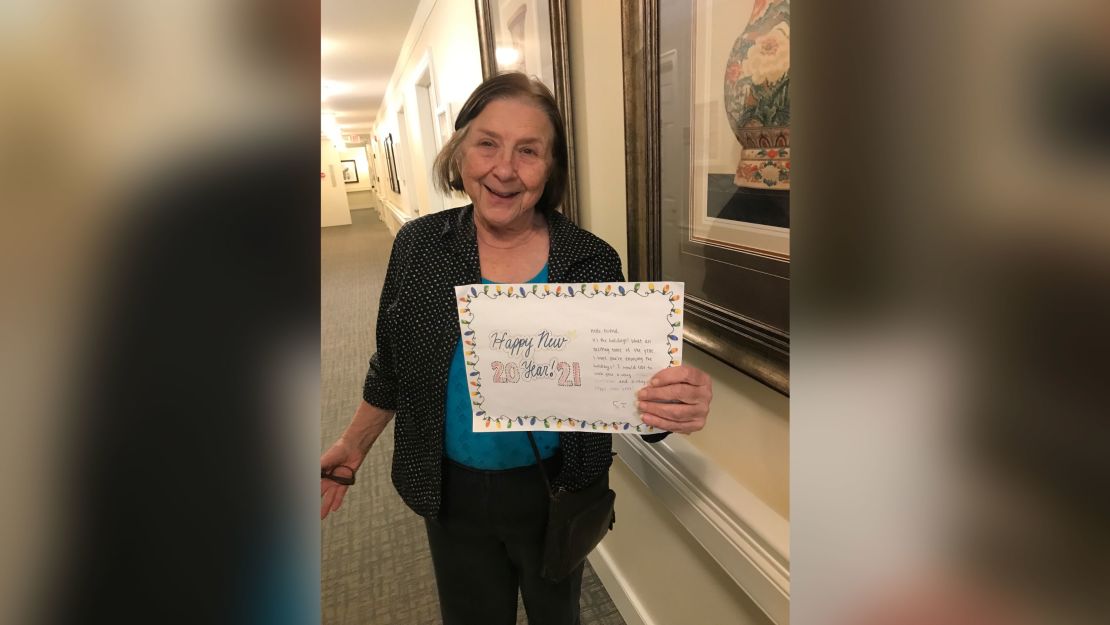 A senior at a nursing home holding one of the cards from Hita and Divit.