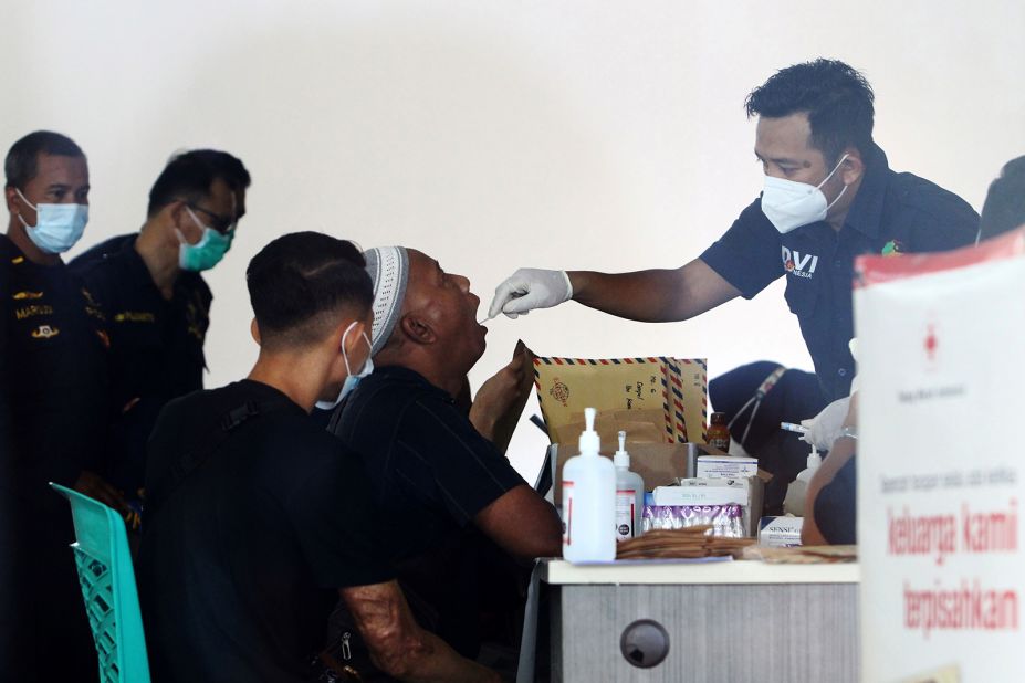 A man is swabbed for his DNA sample at Supadio International Airport. It is to help with the identification of victims.