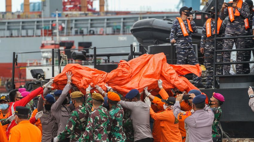TOPSHOT - Rescue workers carry recovered debris at the port in Jakarta on January 10, 2021, during the search operation for Sriwijaya Air flight SJY182 which crashed after takeoff from Jakarta on January 9. (Photo by Dany Krisnadhi / AFP) (Photo by DANY KRISNADHI/AFP via Getty Images)