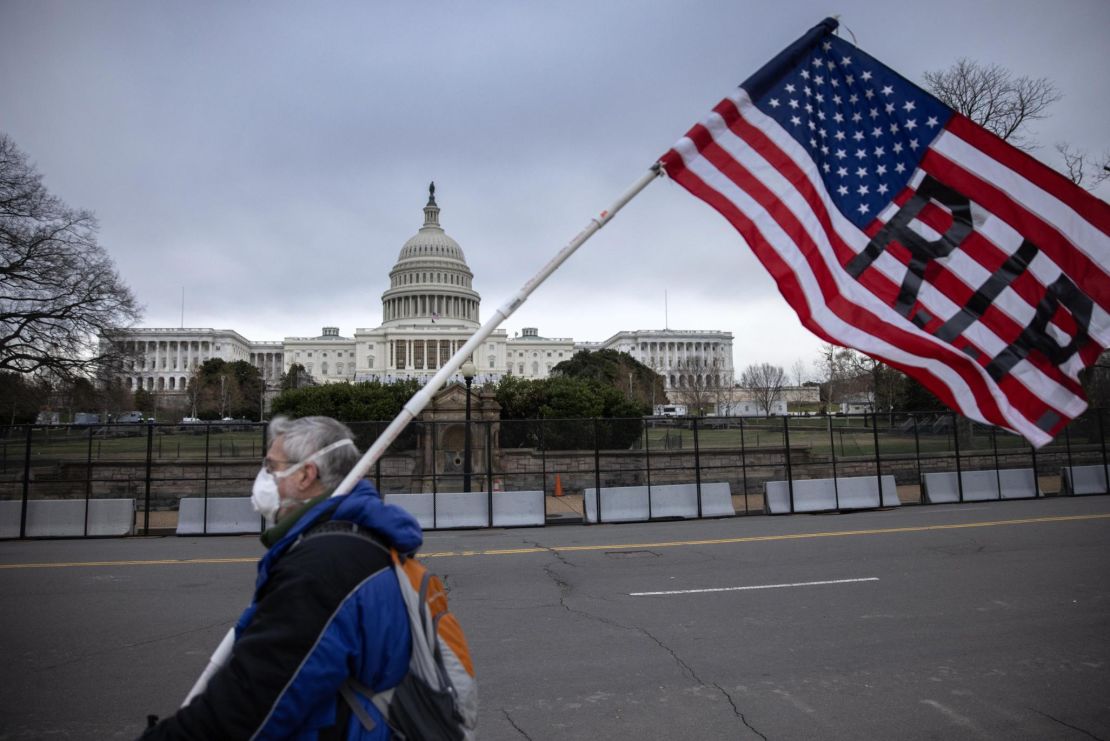 A protester walks by as the American flag flies at half-staff at the US Capitol on January 8, 2021, in Washington.