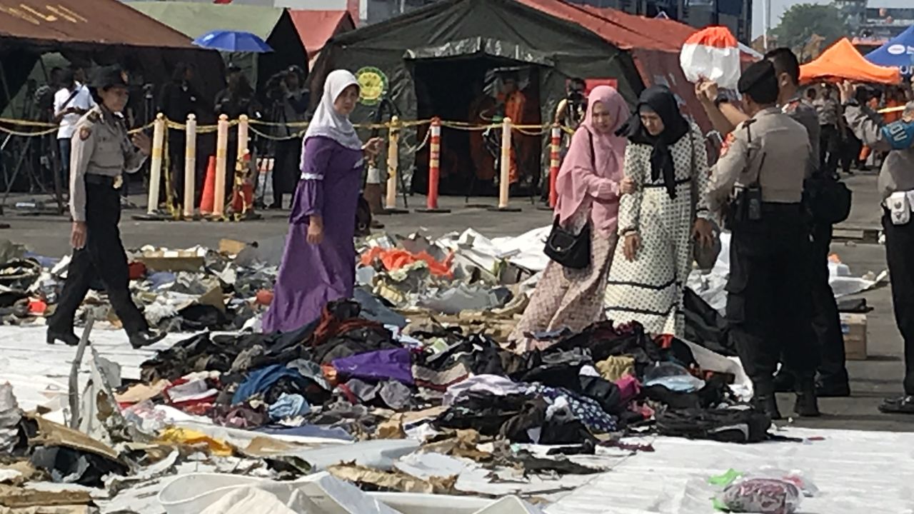 Children's shoes, lined up on a white tarp in the port, as relatives search for items belonging to their loved ones after the October 29, 2018 Lion Air Flight 610 crash.