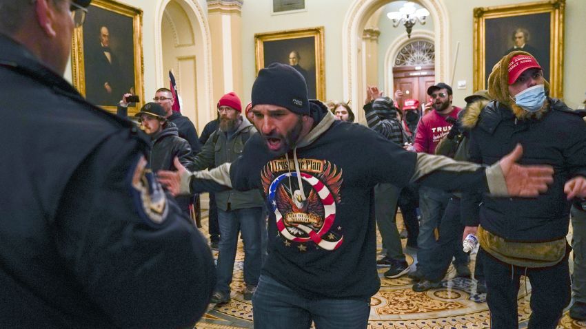 Trump supporters gesture to U.S. Capitol Police in the hallway outside of the Senate chamber at the Capitol in Washington, Wednesday, Jan. 6, 2021. (AP Photo/Manuel Balce Ceneta)
