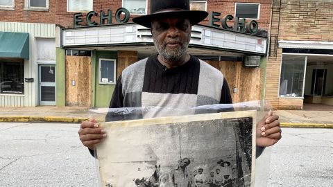 The Rev. David Kennedy stands outside the Echo Theater holding a photo of his great uncle's lynching, in Laurens, South Carolina.