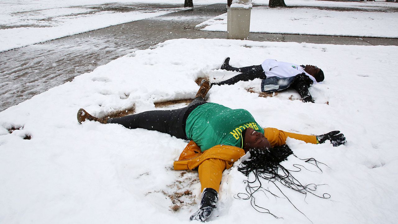 Baylor University students make snow angels after at least 5 inches were reported Sunday.