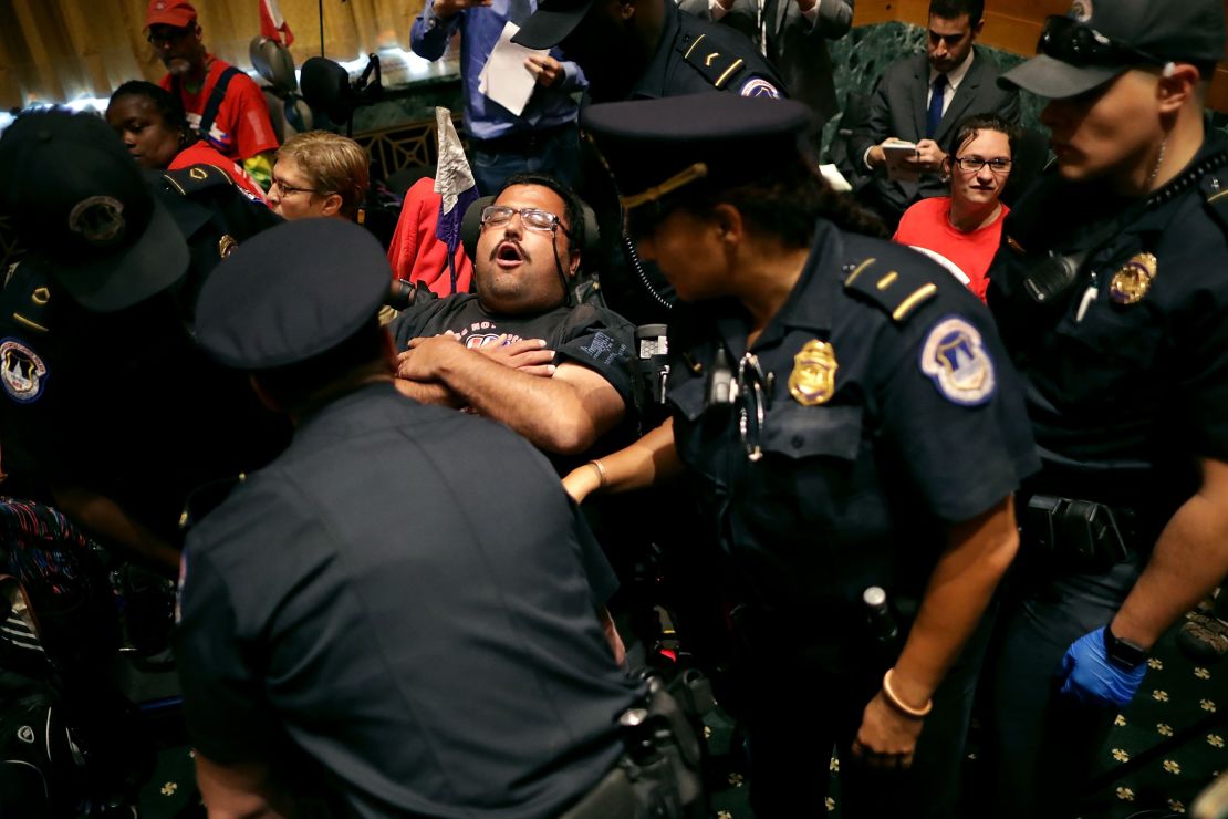 Capitol Police arrest protesters from disabled rights groups as they interrupt a Senate hearing.