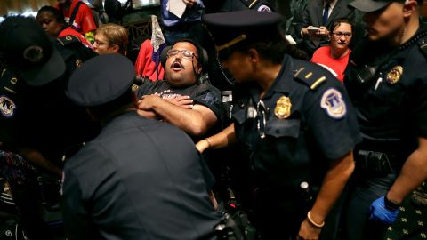 Capitol Police arrest protesters from disabled rights groups as they interrupt a Senate hearing.