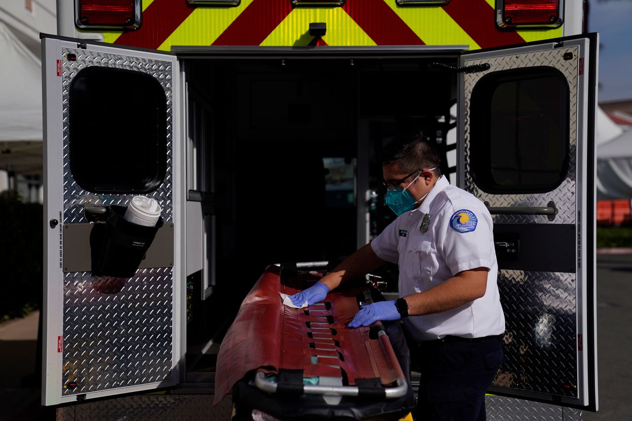 An emergency medical technician disinfects a gurney after transporting a Covid-19 patient in Orange, California.