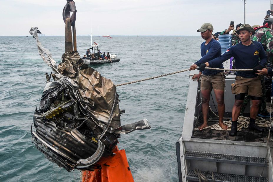 Members of the Indonesian Navy retrieve a piece of debris while searching for the remains of the plane on Monday, January 11.