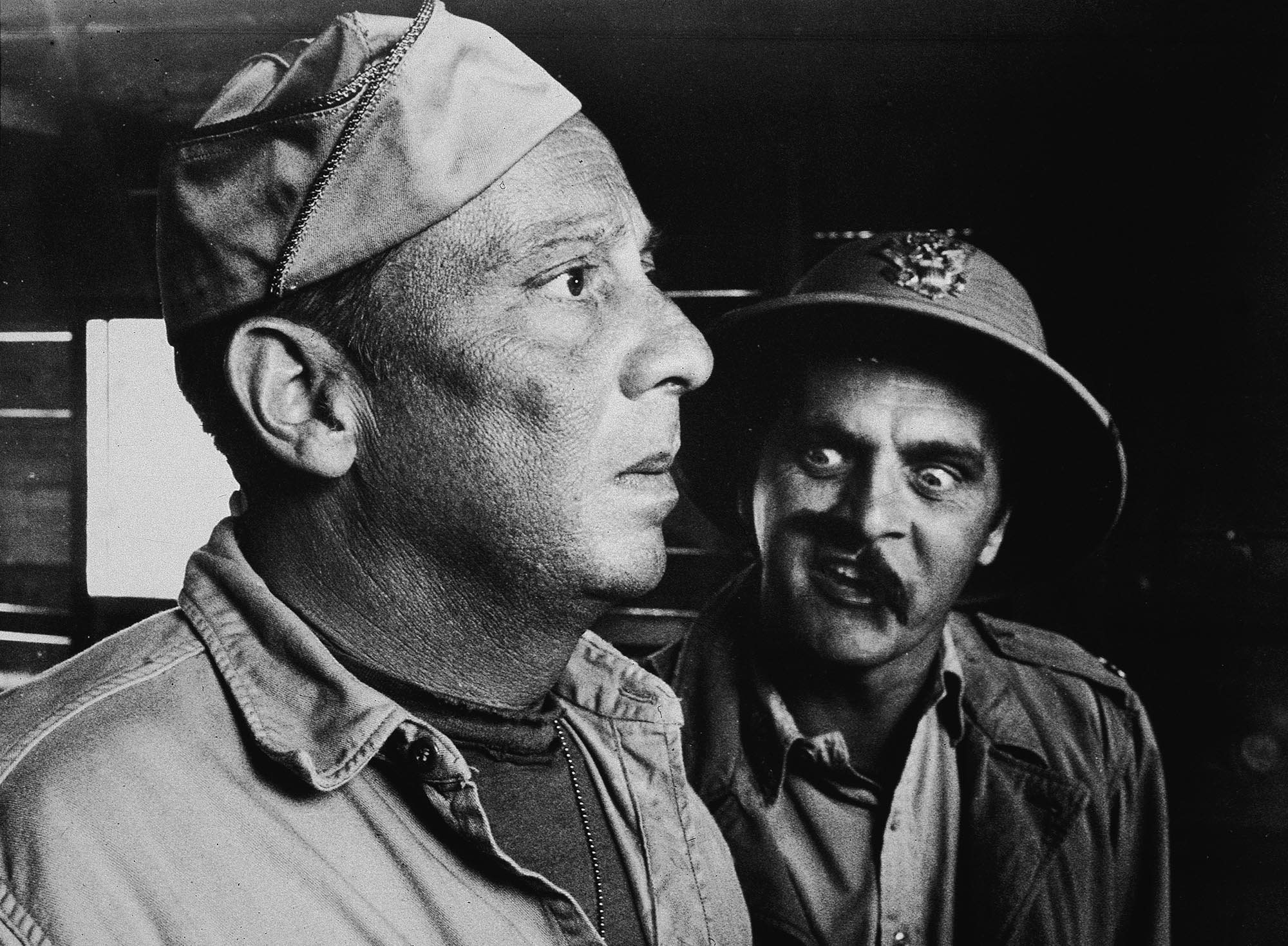 Newhart, sporting a crooked mustache, appears with Norman Fell in a scene from the 1970 film 'Catch-22.'