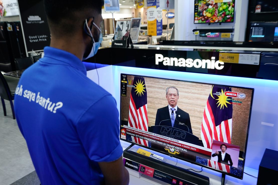 An electronic shop worker watches a live broadcast of Malaysian Prime Minister Muhyiddin Yassin in Kuala Lumpur, Malaysia on January 12.