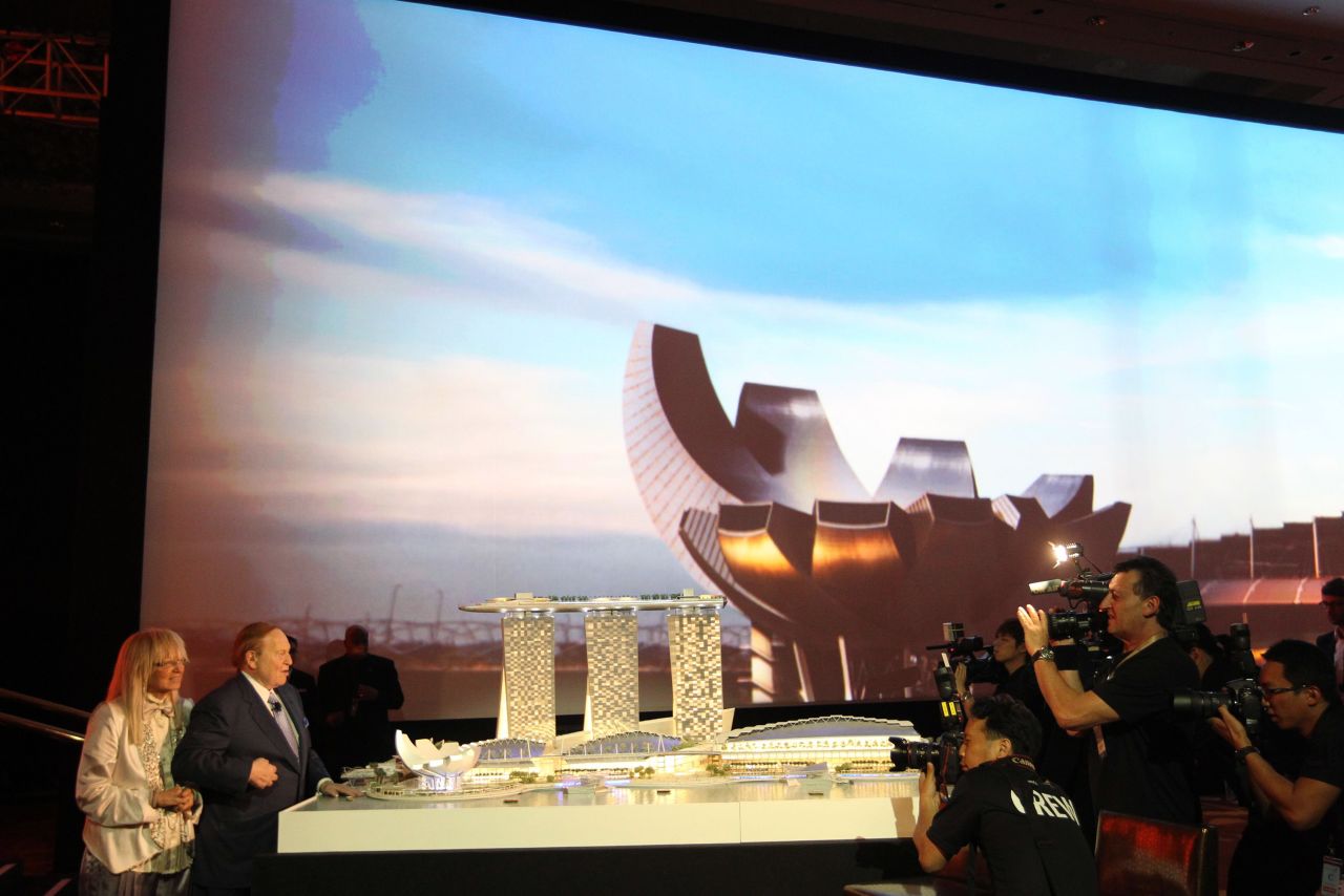 Adelson and his wife stand in front of a model of the Marina Bay Sands in 2010.