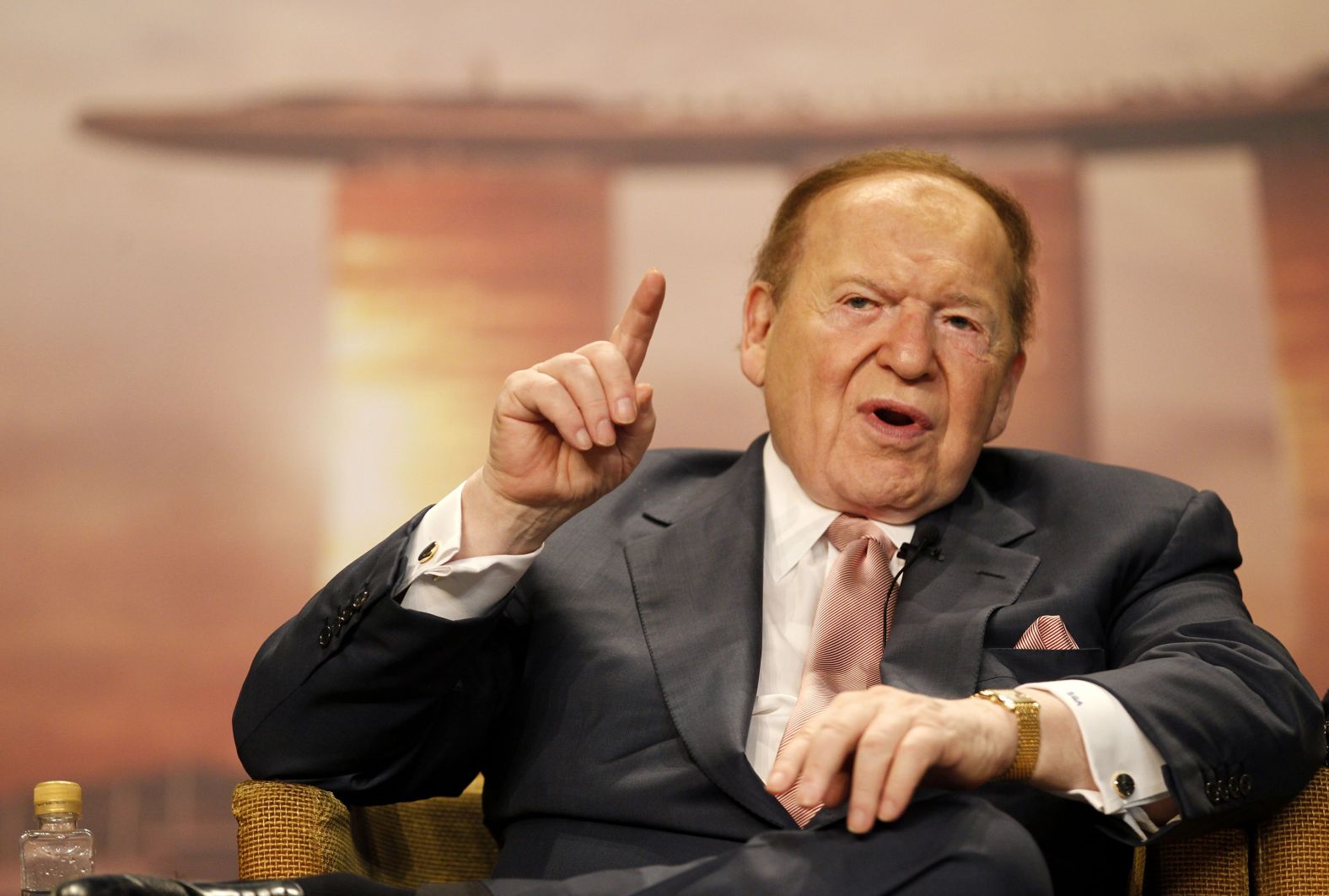 Adelson speaks to the media in Singapore in 2011. In person, Adelson was instantly recognizable for his thinning patch of bright red hair and the electric scooter he rode everywhere. He suffered from peripheral neuropathy, a condition that made walking difficult.