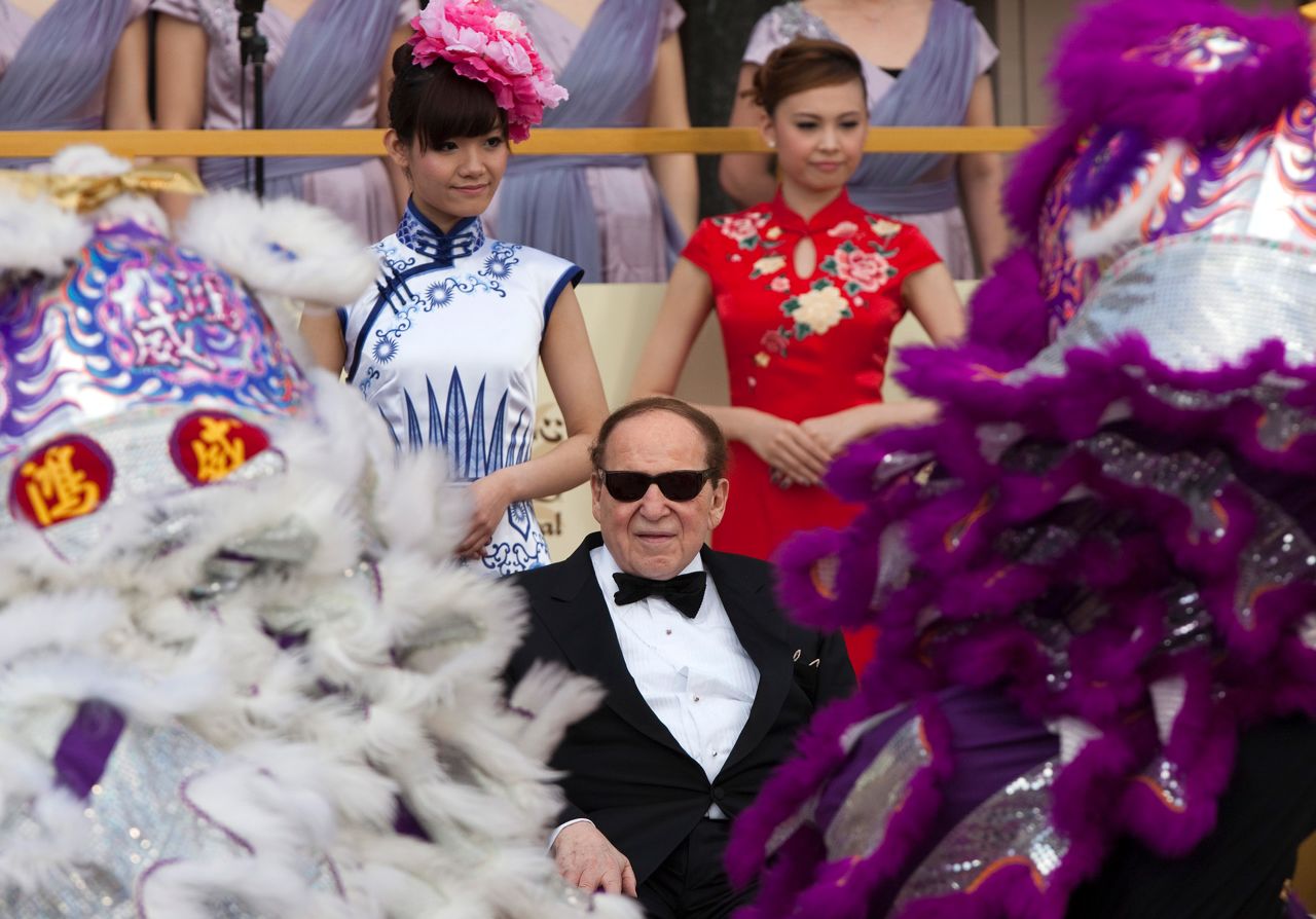 Adelson watches a traditional lion dance in Macao during the opening of the Sands Cotai Central resort in 2012.