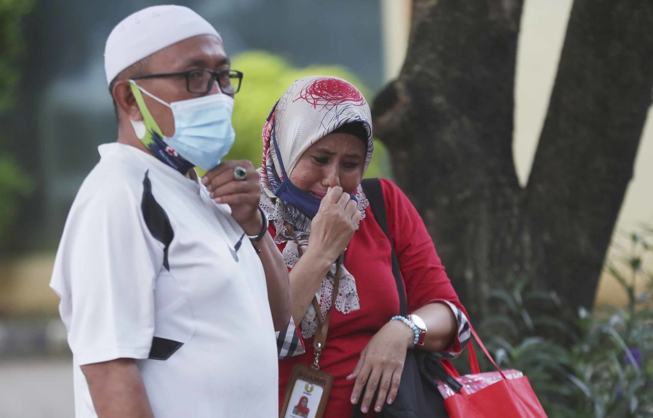 Relatives of Panca Widia Nursanti, one of the crash victims, react at a hospital in Jakarta on January 12.