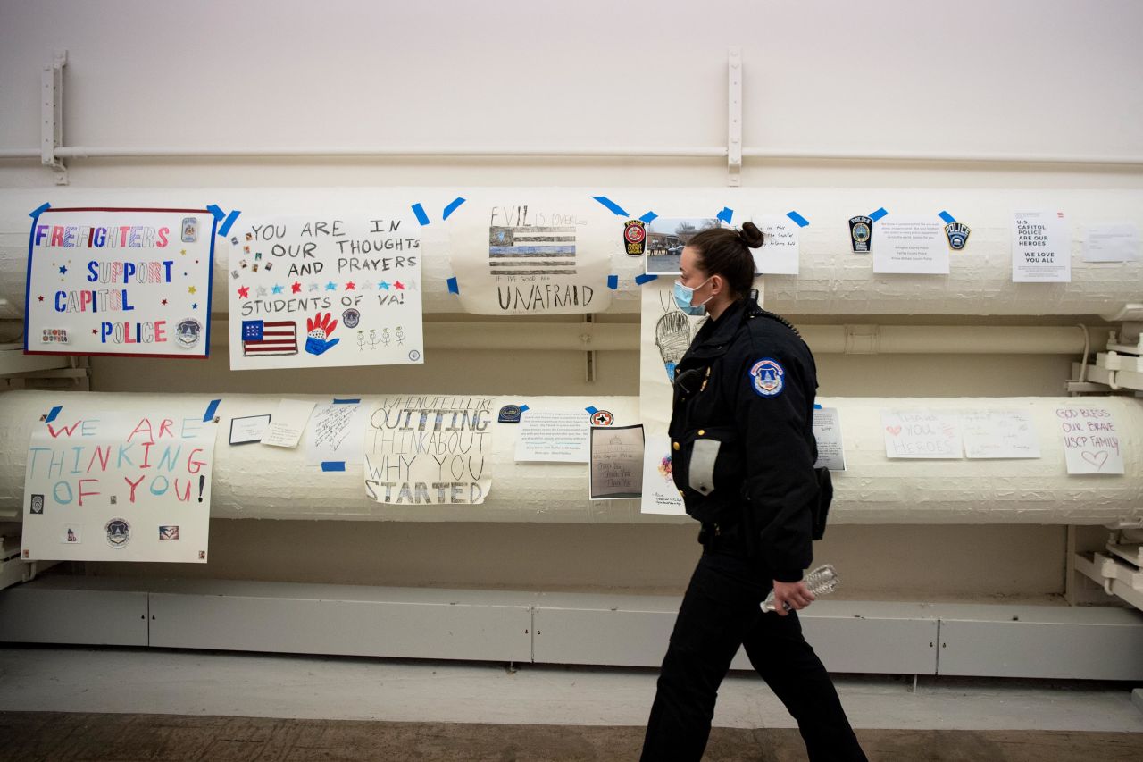 An officer views a collection of signs thanking Capitol Police.