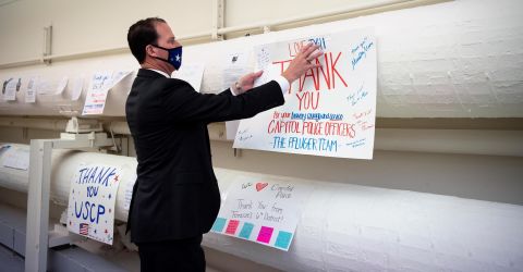Rep. August Pfluger, R-Texas, hangs up a thank you sign in the Cannon Tunnel hallway as a part of a collection of signs thanking Capitol Police after the insurrection in the Capitol the previous week on Tuesday, January 12.