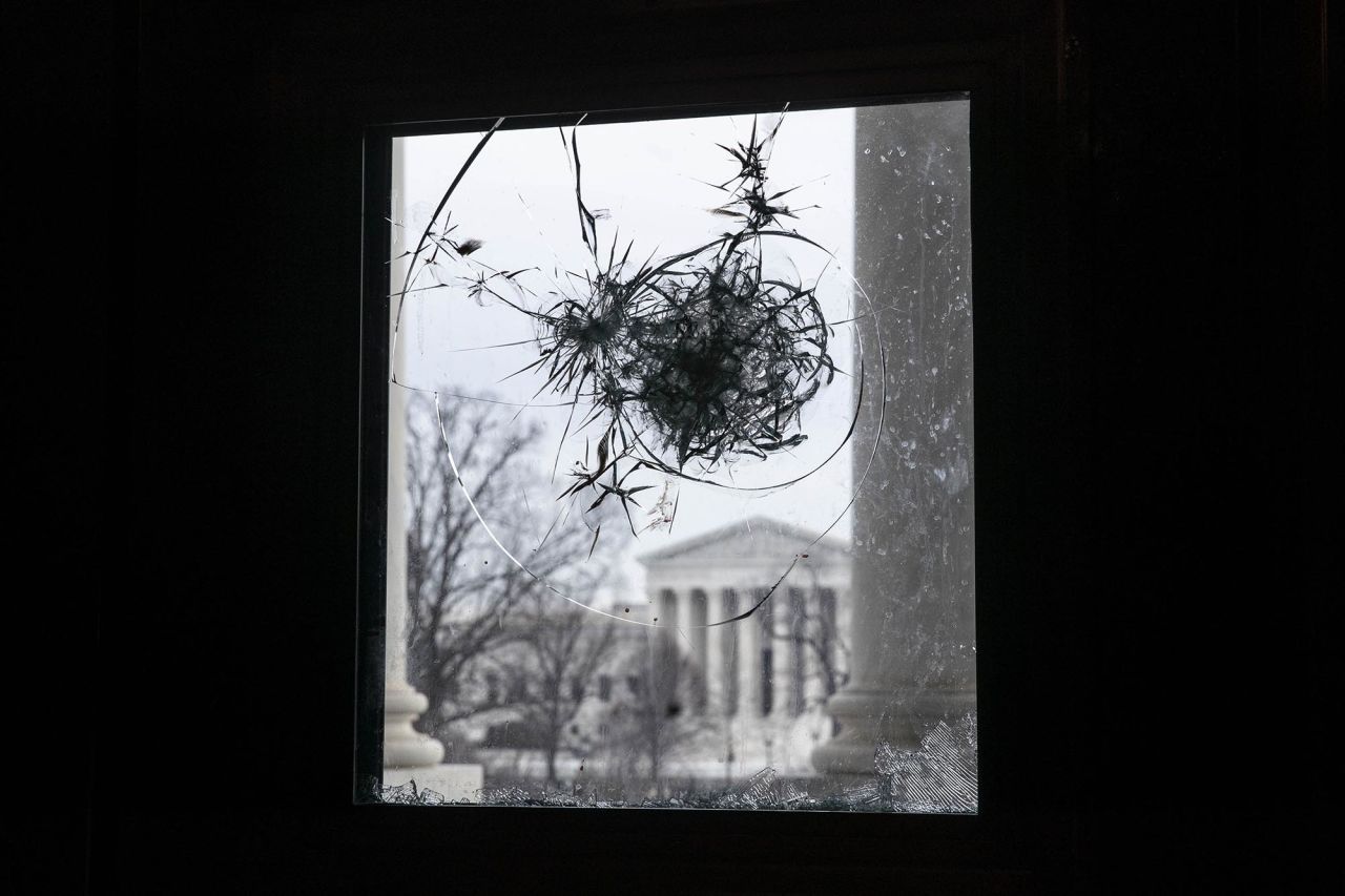 The US Supreme Court can be seen through a broken window at the US Capitol on January 11.