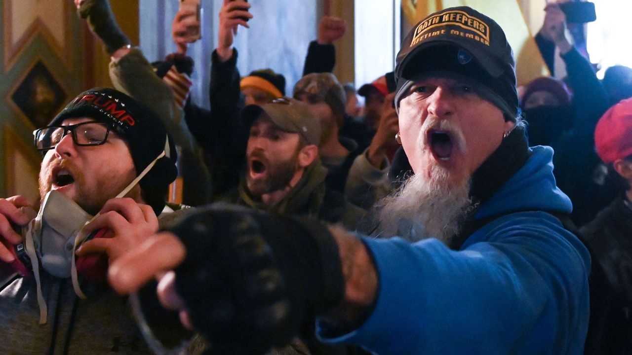 A man wearing an Oath Keepers hat is among the mob inside the US Capitol on January 6 in Washington, DC. The Oath Keepers is a pro-Trump, far-right, anti-government group that tries to recruit members from active or retired military.