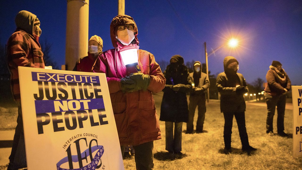 Bloomington anti-death-penalty activist Glenda Breeden holds a lamp while protesting against the execution of Lisa Montgomery and two others.