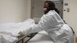 Funeral home transporter Morgan Dean-McMillan prepares to transport a suspected Covid-19 positive body in a hospital's morgue in Baltimore, Maryland on December 23, 2020 during the Covid-19 pandemic. - The United States surpassed 18 million reported Covid-19 cases on Monday, figures from Johns Hopkins University showed, as the virus surges nationwide. When it comes to vaccination priority, long-term care residents and health workers are at the front of the line. Maryland crematorium owner Dorota Marshall hopes that her workers going to do pickups and regularly entering hospitals, hospices, nursing homes and residences, get the vaccine in the next round. Marshall says "We visit homes where people recently died from Covid or family members are positive, so absolutely I think we are front line workers." (Photo by Andrew Reynolds/AFP/Getty Images)