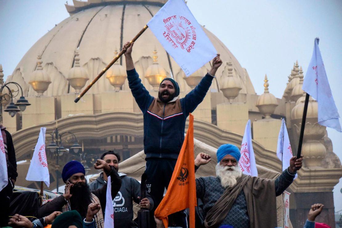 Farmers shout slogans as they depart Amritsar for Delhi to participate in protests on January 12.