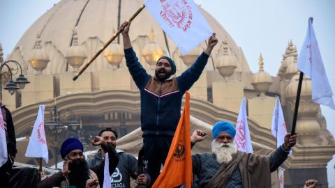 Farmers shout slogans as they depart Amritsar for Delhi to participate in protests on January 12.