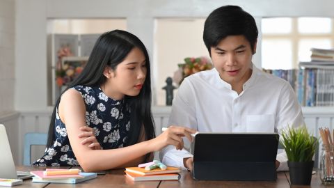 young asian couple on laptop looking for term life insurance
