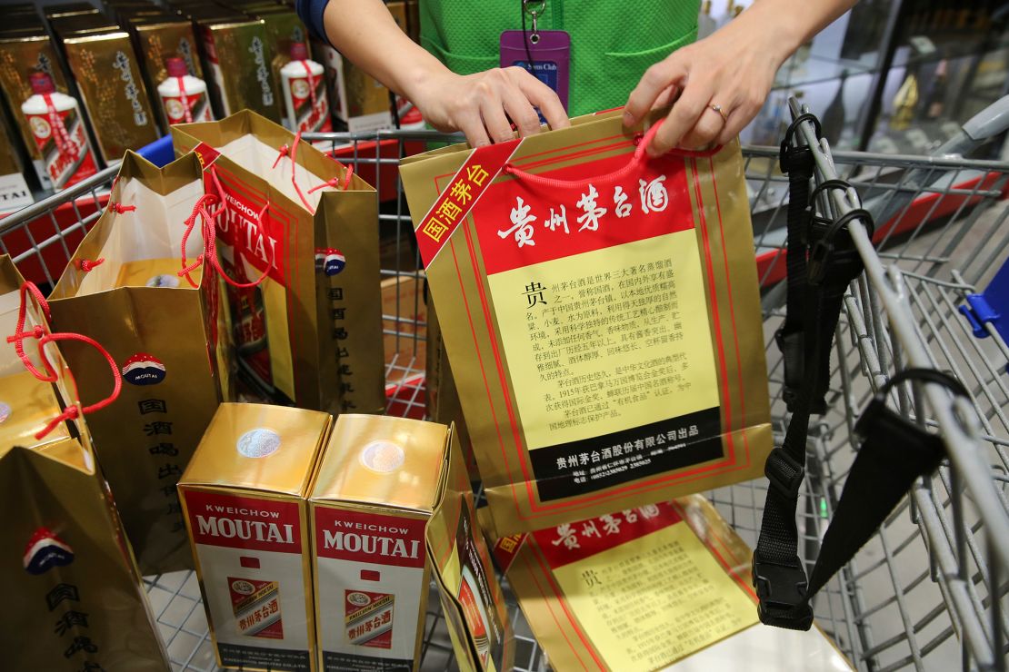 An employee displays China's leading liquor maker Kweichow Moutai at a supermarket in Nantong city, in China's Jiangsu province in 2018.