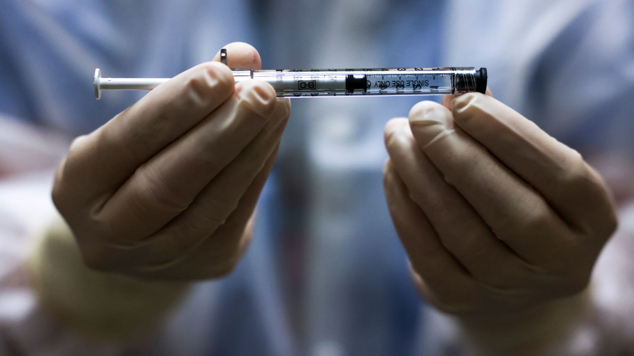 AURORA, CO - DECEMBER 15: (EDITORIAL USE ONLY) Rocky Mountain Regional VA Medical Center investigational pharmacy technician Sara Berech holds a dose of the Johnson & Johnson COVID-19 vaccine before it is administered in a clinical trial on December 15, 2020 in Aurora, Colorado. The Johnson & Johnson vaccine could be submitted for emergency use by late January and is the only vaccine among leading candidates given as a single dose. (Photo by Michael Ciaglo/Getty Images)