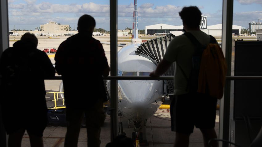 Passengers look out at American Airlines flight 718, a Boeing 737 Max, parked at its gate at Miami International Airport as people load for the flight to New York on December 29, 2020 in Miami, Florida. The Boeing 737 Max flew its first commercial flight since the aircraft was allowed to return to service nearly two years after being grounded worldwide following a pair of separate crashes. (Photo by Joe Raedle/Getty Images)