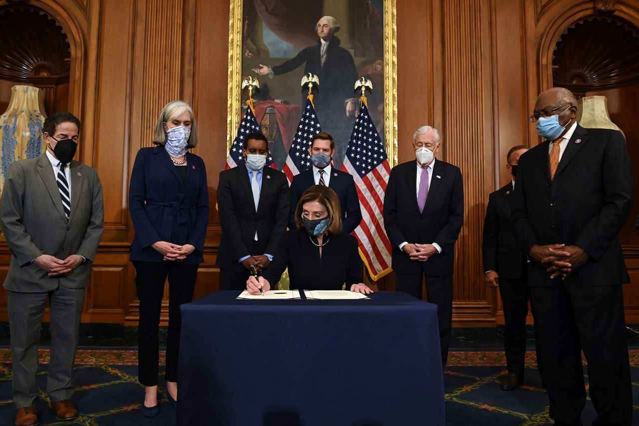 House Speaker Nancy Pelosi signs the article of impeachment after the House vote on January 13.