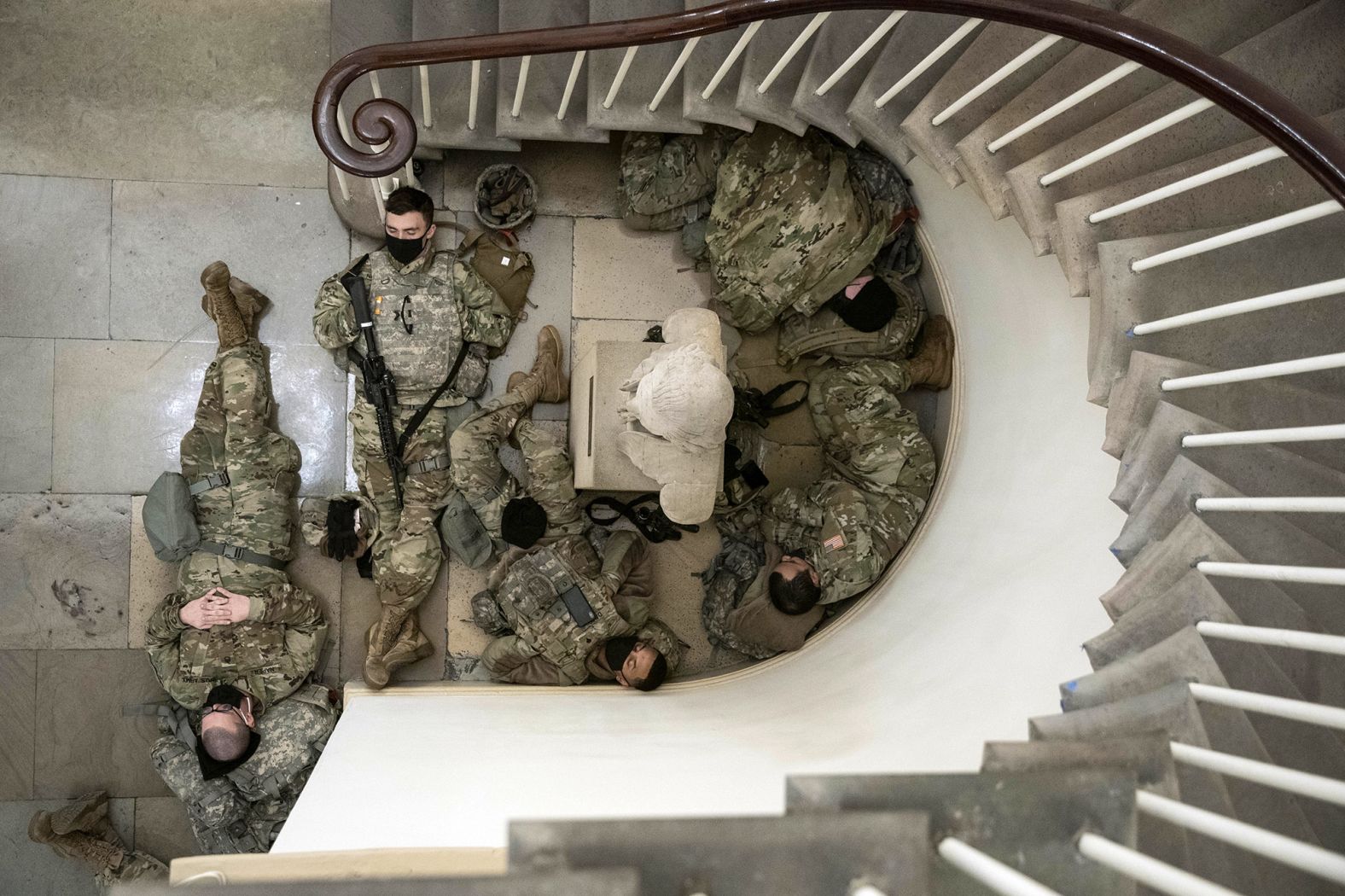 Members of the National Guard rest near a staircase in the Capitol on January 13. Thousands of National Guard troops were guarding every nook of the Capitol complex ahead of Joe Biden's inauguration.
