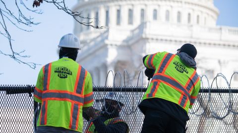 Barbed wire is installed on the top of a security fence surrounding the Capitol.