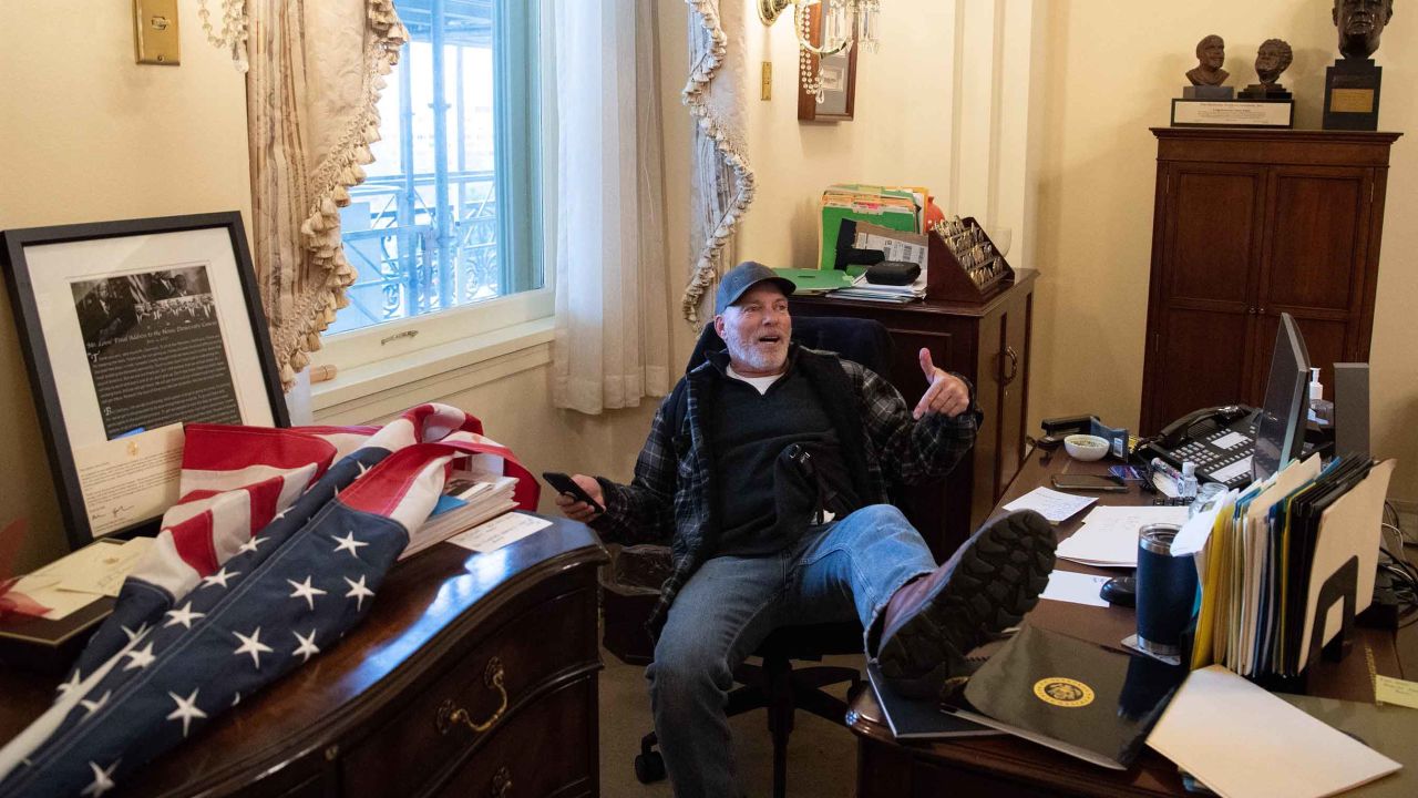 Richard Barnett, a supporter of US President Donald Trump, sits inside the office of US Speaker of the House Nancy Pelosi on January 6, 2021.