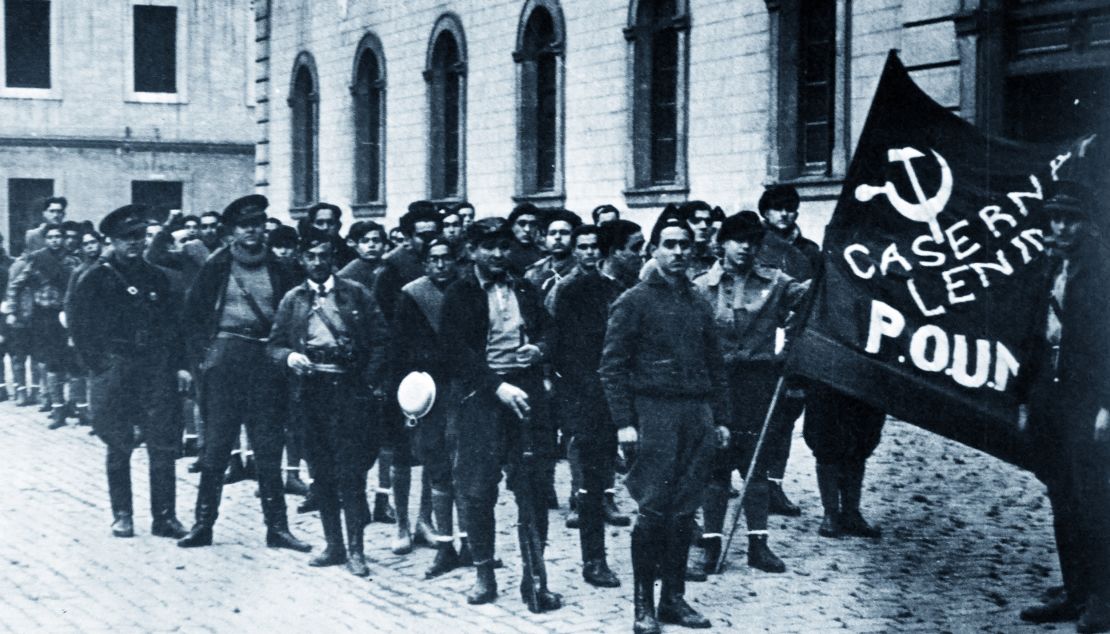 POUM militia guards the Headquarters of the POUM in Barcelona 1936. In the background stands British writer George Orwell. 