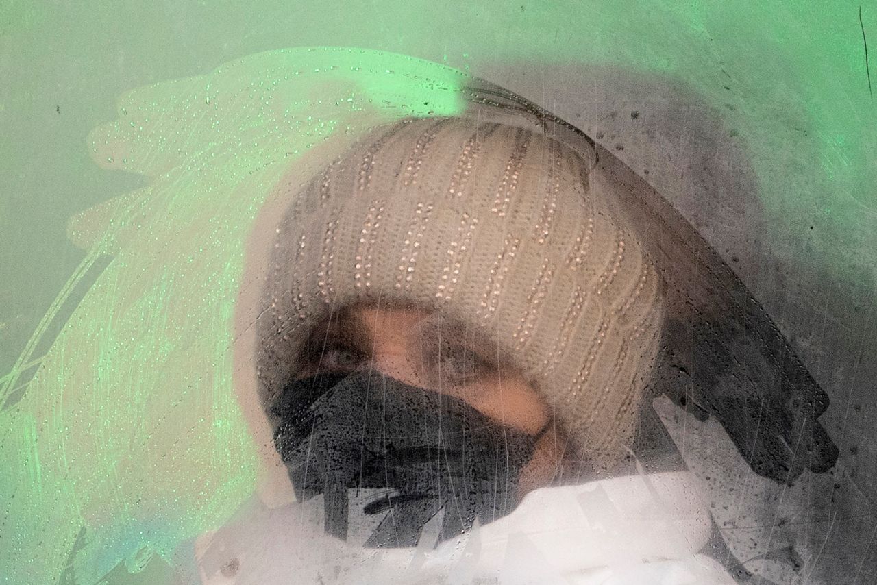 A woman wearing a face mask looks out from a fogged bus window in Ivano-Frankivsk, Ukraine, on Friday, January 8. 