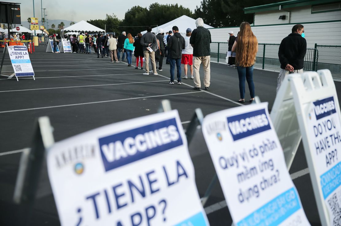 People wait in line to get the Covid-19 vaccine on January 13 at a mass vaccination site in a parking lot at Disneyland Resort in Anaheim, California.