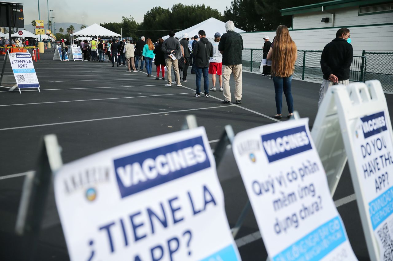 People wait in line to get the Covid-19 vaccine on January 13 at a mass vaccination site in a parking lot at Disneyland Resort in Anaheim, California.