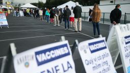 ANAHEIM, CALIFORNIA - JANUARY 13: People wait in line to receive the COVID-19 vaccine at a mass vaccination site in a parking lot for Disneyland Resort on January 13, 2021 in Anaheim, California. California announced that effective immediately, all residents 65 or older are eligible to receive the vaccine. (Photo by Mario Tama/Getty Images)