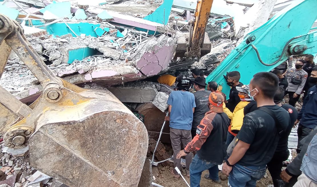 Rescuers search for survivors at a collapsed building in Mamuju city in Indonesia.
