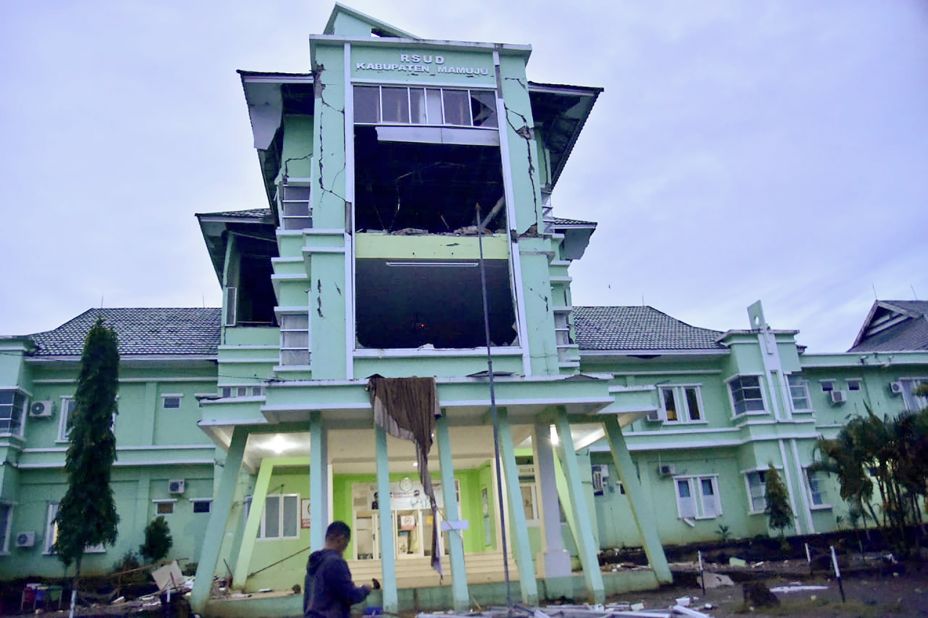 A person passes by a damaged hospital in Mamuju.