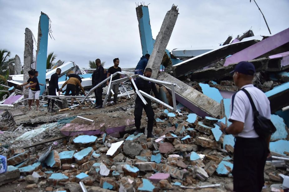 Emergency workers remove rubble in search of survivors at the Mitra Manakarra hospital in Mamuju.