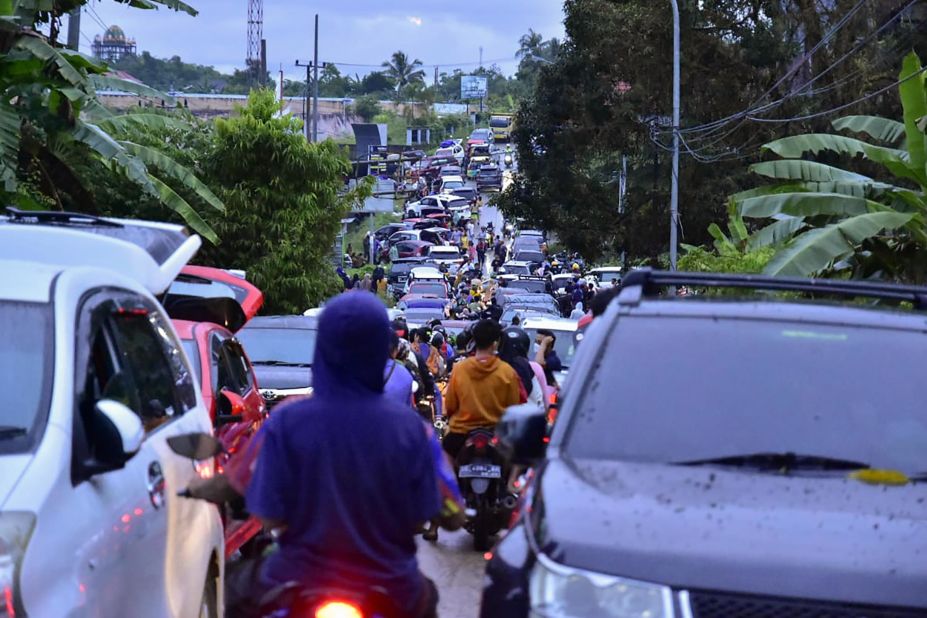 Residents crowd a road as they attempt to evacuate Mamuju.