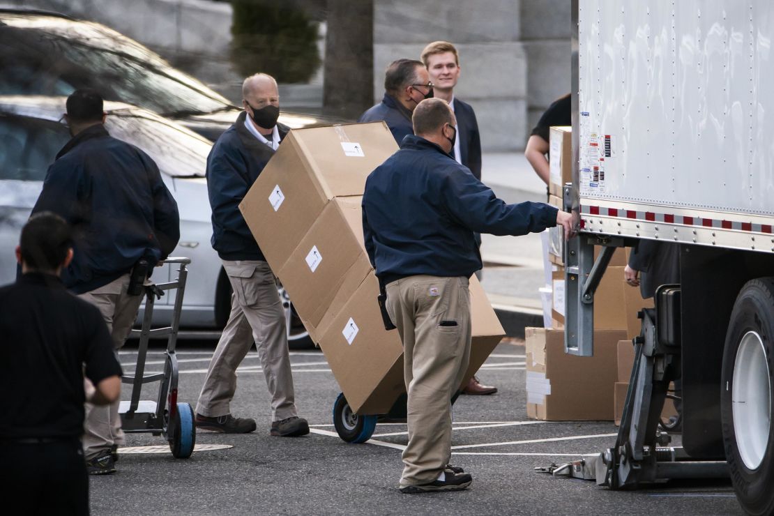 Workers move boxes onto a truck on West Executive Avenue between the White House and the Eisenhower Executive Office Building on Thursday, Jan. 14, 2021.