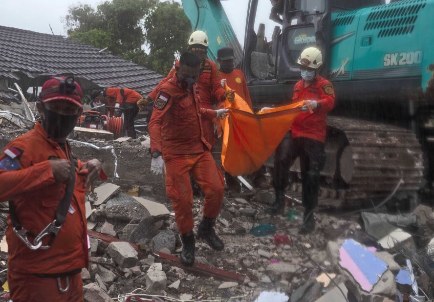 The body of a child is recovered from the rubble.